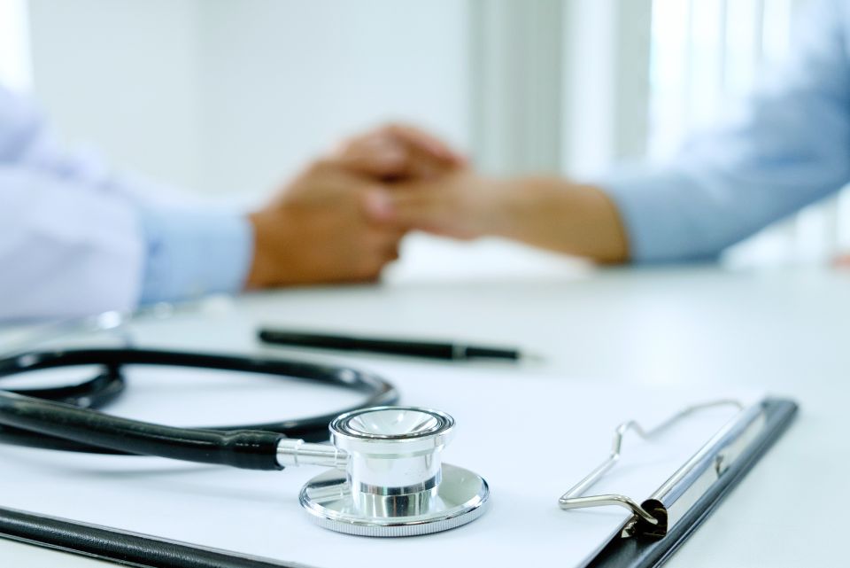 Healthcare provider gently holding a patient’s hands during a consultation, representing Mind Rejuvenation’s caring clinical team